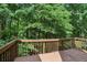 Cozy wooden deck overlooking a lush green forest, perfect for enjoying nature and outdoor relaxation at 1945 Grayson Oaks Ct, Lawrenceville, GA 30045