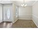 Cozy dining area with neutral walls and chandelier, adjacent to the front door at 1945 Grayson Oaks Ct, Lawrenceville, GA 30045
