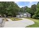 Well-kept one-story home featuring a stone facade, wide driveway, and mature trees at 1945 Grayson Oaks Ct, Lawrenceville, GA 30045