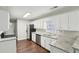 Galley kitchen features white cabinets, stainless appliances, and stone countertops at 1945 Grayson Oaks Ct, Lawrenceville, GA 30045