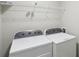 A laundry room featuring a white wire shelf and matching washer and dryer units at 1945 Grayson Oaks Ct, Lawrenceville, GA 30045