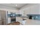 Modern kitchen with stainless steel appliances, white cabinets, and blue backsplash at 248 Colony Center Dr, Woodstock, GA 30188