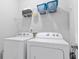 Functional laundry room featuring a white washer and dryer, and convenient wire shelving for storage at 248 Colony Center Dr, Woodstock, GA 30188