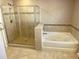 Spa-like bathroom featuring a glass-enclosed shower, a soaking tub, and elegant tile work at 3687 Thackary Dr, Powder Springs, GA 30127