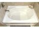Clean bathtub with stylish tiles, fixtures, and soothing ambiance perfect for a relaxing bath at 3687 Thackary Dr, Powder Springs, GA 30127