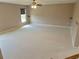 Spacious bonus room featuring plush carpet, neutral walls, a ceiling fan, and a large window at 3687 Thackary Dr, Powder Springs, GA 30127