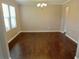 Dining room with hardwood floors, modern chandelier, and bright, natural light through many windows at 3687 Thackary Dr, Powder Springs, GA 30127