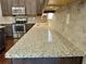Modern kitchen featuring granite countertops, stainless steel appliances, and dark wood cabinetry at 3687 Thackary Dr, Powder Springs, GA 30127