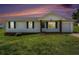 Charming home exterior featuring vinyl siding, a porch, and a well-maintained lawn at 5794 Parks Rd, Cumming, GA 30041