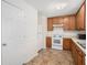 View of kitchen featuring wood cabinets and white appliances; adjacent door and pantry enhance functionality at 5794 Parks Rd, Cumming, GA 30041