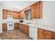 Functional kitchen featuring classic wood cabinets, white appliances, and neutral countertops at 5794 Parks Rd, Cumming, GA 30041