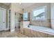 Luxurious bathroom with a soaking tub, a glass-enclosed shower, and neutral tile work offering a spa-like retreat at 631 Mabry Rd, Sandy Springs, GA 30328