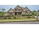 Beautiful two-story home with stone and siding, complimented by a meticulously maintained lawn and wrought iron fence at 631 Mabry Rd, Sandy Springs, GA 30328