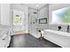 Bright bathroom with sleek marble details, a glass-enclosed shower, and a luxurious soaking tub beneath a frosted window at 801 Braselton Hwy, Lawrenceville, GA 30043