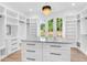 Spacious walk-in closet with custom shelving, drawers, an island, and a contemporary chandelier, offering ample storage at 801 Braselton Hwy, Lawrenceville, GA 30043