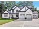Striking white brick home featuring black trim, three-car garage, and well-manicured lawn at 801 Braselton Hwy, Lawrenceville, GA 30043