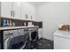 Well-lit laundry room with modern washer, dryer, countertops, and backsplash at 801 Braselton Hwy, Lawrenceville, GA 30043