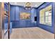 Stylish home office featuring a modern chandelier, blue walls, and hardwood floors at 801 Braselton Hwy, Lawrenceville, GA 30043