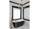 A modern bathroom boasts an elegant black freestanding tub with gold hardware and a stylish light fixture at 1186 Lincoln Dr, Marietta, GA 30066