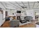 Open living room with coffered ceilings, fireplace, large screen tv, bar area, and hardwood floors at 1186 Lincoln Dr, Marietta, GA 30066