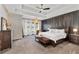 Bright main bedroom with tray ceilings, dark wooden accents, a patterned accent wall and large windows at 1186 Lincoln Dr, Marietta, GA 30066