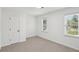 Bright bedroom features fresh paint, neutral carpet, two windows, and a door with a black handle at 4581 Hickory Run Nw Ct, Acworth, GA 30102