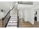 Bright and airy entryway featuring hardwood floors, staircase with black railing, and modern lighting at 4581 Hickory Run Nw Ct, Acworth, GA 30102