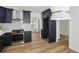 Stunning kitchen featuring navy cabinets, stainless steel appliances, and a stylish subway tile backsplash at 4581 Hickory Run Nw Ct, Acworth, GA 30102