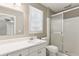 Bathroom featuring white vanity, toilet, shower, large mirror and window for plenty of natural light at 553 Candlewood Dr, Stone Mountain, GA 30088
