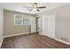 Bedroom with a ceiling fan, wood floors, and a window with natural light and spacious double-door closet at 553 Candlewood Dr, Stone Mountain, GA 30088