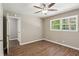 Bedroom with ceiling fan, hardwood floors and window overlooking lush green trees with ample natural light at 553 Candlewood Dr, Stone Mountain, GA 30088