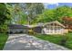 Charming single-story home featuring a well-manicured lawn, mature trees, and a long driveway at 553 Candlewood Dr, Stone Mountain, GA 30088