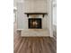 Cozy living room featuring a classic brick fireplace with a wooden mantel and modern wood-look floors at 553 Candlewood Dr, Stone Mountain, GA 30088