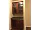 A dark wood kitchenette features glass-front cabinets, granite counters, and a convenient built-in wine rack for the wine lover at 1186 Ridenour Blvd # 5, Kennesaw, GA 30152