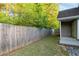 Side view of home features a wooden fence and an expansive grassy yard at 191 Misty Ridge Trl, Stockbridge, GA 30281