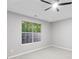 Bright bedroom featuring a ceiling fan and a large window with a view of the trees outside at 191 Misty Ridge Trl, Stockbridge, GA 30281