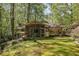 Scenic backyard featuring a charming home with a screened porch, lush lawn, and mature trees offering privacy at 3311 Stillhouse Se Rd, Atlanta, GA 30339