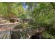 Secluded home exterior featuring bridge over creek, natural surroundings, and a portico driveway entrance at 3311 Stillhouse Se Rd, Atlanta, GA 30339