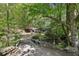 Beautiful home exterior with lush landscaping and a bridge over a creek at 3311 Stillhouse Se Rd, Atlanta, GA 30339