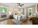 Cozy bedroom with natural light, a ceiling fan, hardwood floors, and a comfortable queen bed at 385 Russell Ridge Dr, Lawrenceville, GA 30043