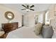 Bright bedroom featuring a ceiling fan, light walls, a wood dresser, and a large bed at 385 Russell Ridge Dr, Lawrenceville, GA 30043