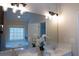Bright bathroom featuring double sinks, a large mirror, and a separate soaking tub by the window at 5424 Landsdowne Ct, Cumming, GA 30041