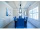 Cozy dining room with wainscoting, blue chairs, and a view to the kitchen at 5424 Landsdowne Ct, Cumming, GA 30041