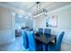 Formal dining room boasts modern lighting, blue chair covers, and wainscoting detail at 5424 Landsdowne Ct, Cumming, GA 30041
