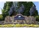 Stone entrance to the Windermere community with unique sculptures and manicured flower beds at 5424 Landsdowne Ct, Cumming, GA 30041