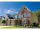 This brick and siding home features a manicured lawn, a two-car garage, and is full of natural light at 5424 Landsdowne Ct, Cumming, GA 30041