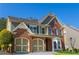 This two-story brick and siding home has a well-manicured lawn and a convenient two-car garage at 5424 Landsdowne Ct, Cumming, GA 30041