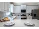 Modern kitchen features white cabinets, stainless appliances, and stylish backsplash at 5424 Landsdowne Ct, Cumming, GA 30041