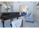 Inviting living room featuring a grand piano, stylish seating, and an open view into the dining area at 5424 Landsdowne Ct, Cumming, GA 30041