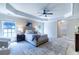Spacious primary bedroom with tray ceiling, a ceiling fan, and large windows bringing in lots of natural light at 5424 Landsdowne Ct, Cumming, GA 30041